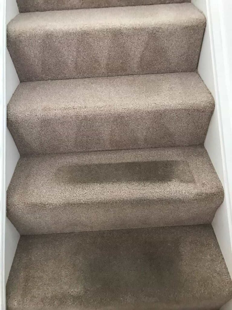 this is a photo of a staircase with beige carpets that is in the process of being cleaned works carried out by Buckhurst Hill Carpet Cleaning