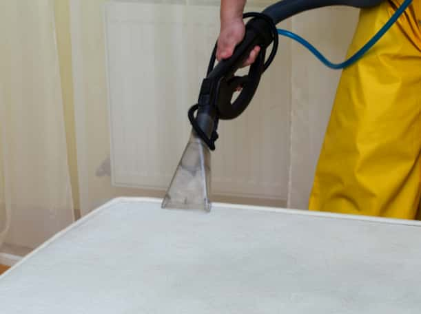 This is a photo of a man steam cleaning a dirty mattress works carried out by Buckhurst Hill Carpet Cleaning